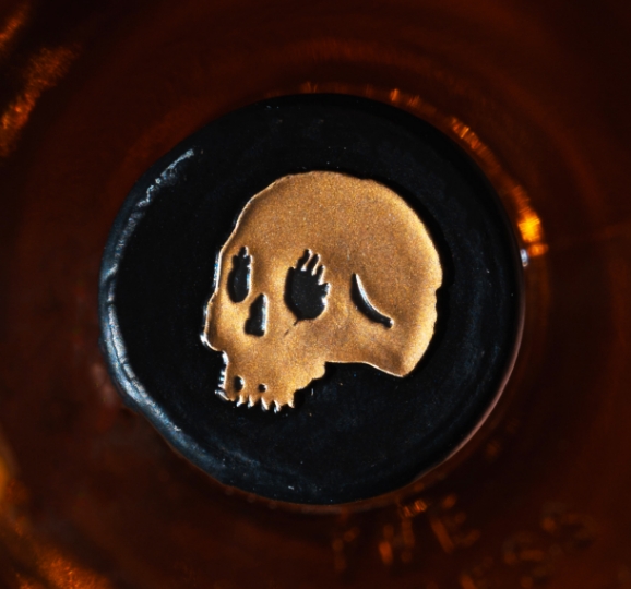 Close up of skull logo on whiskey bottle cap.