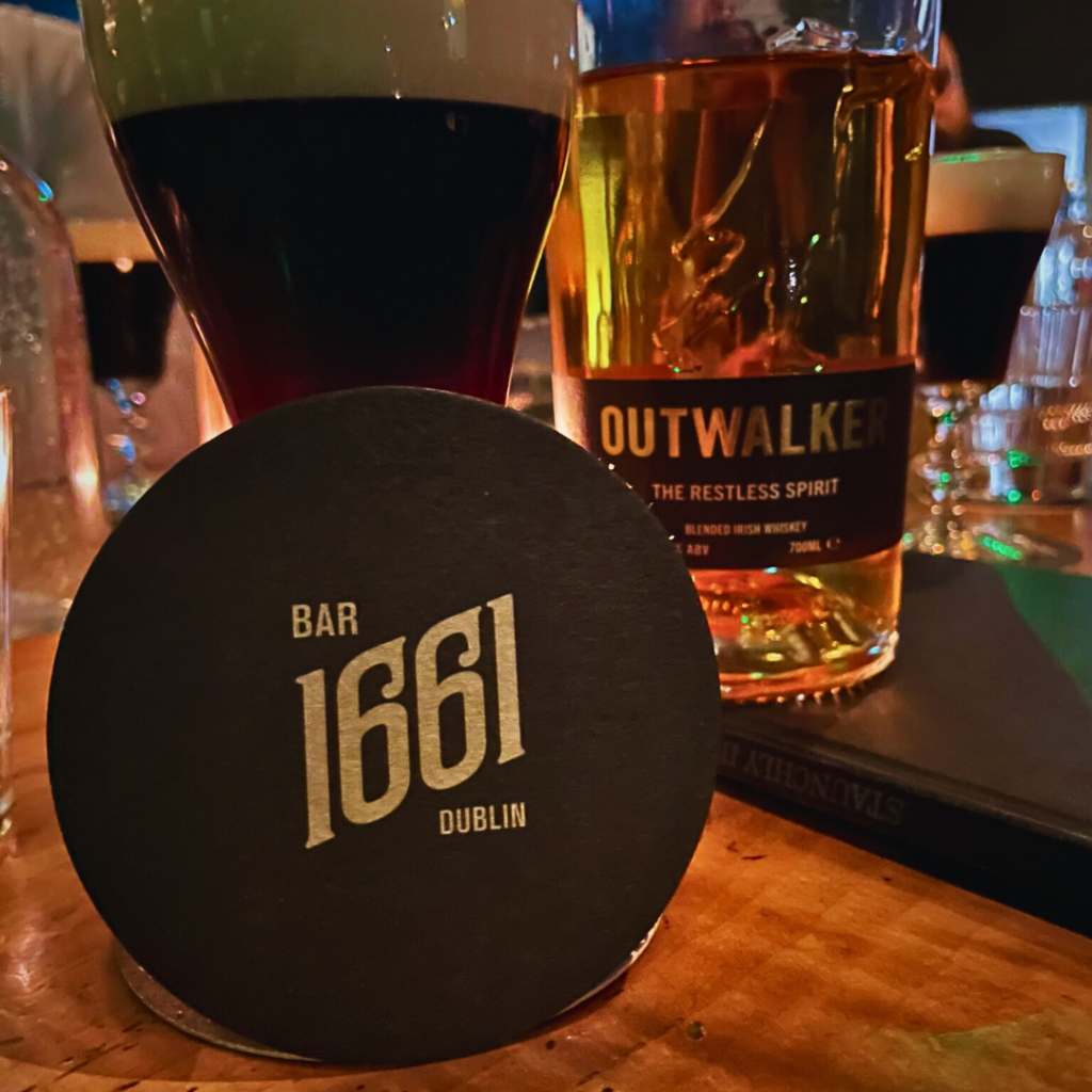 An Outwalker Whiskey cocktail with a beer mat resting against it.
