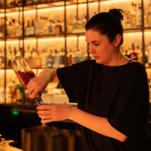 Jillian Vose mixing an Outwalker Whiskey cocktail at a bar.
